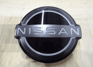 62890-6RA0A 628906RA0A NISSAN Rogue Emblemat Znaczek Grill Zderzak Przód 1